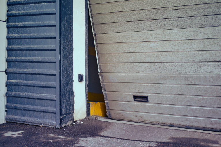 Broken warehouse door panel being replaced by a professional technician